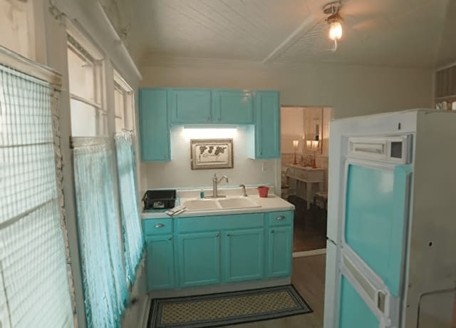 A kitchen with blue cabinets and white counters.