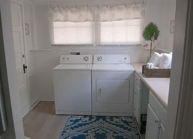 A kitchen with two white appliances and a blue rug.