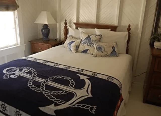 A bed with a blue and white blanket on it
