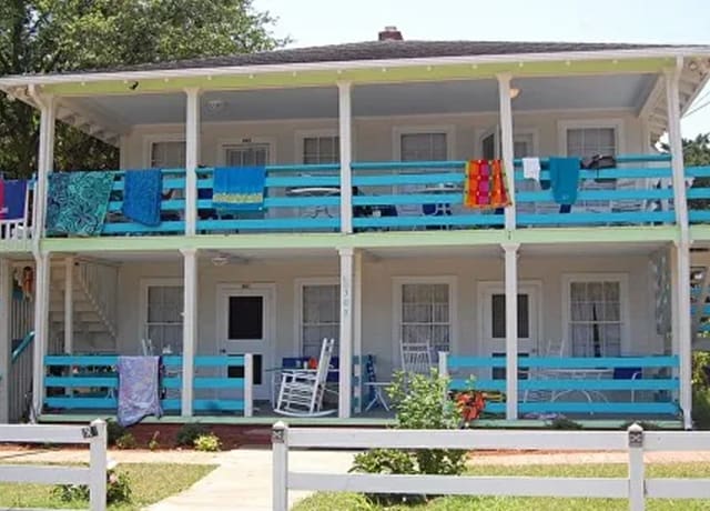 A motel with blue painted balconies and white trim.
