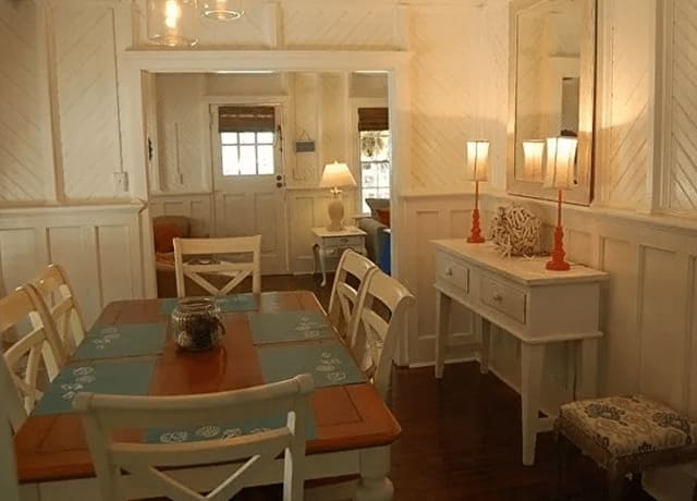 A dining room with white walls and wooden furniture.
