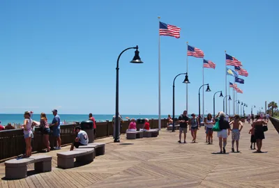 A group of people walking on the boardwalk.