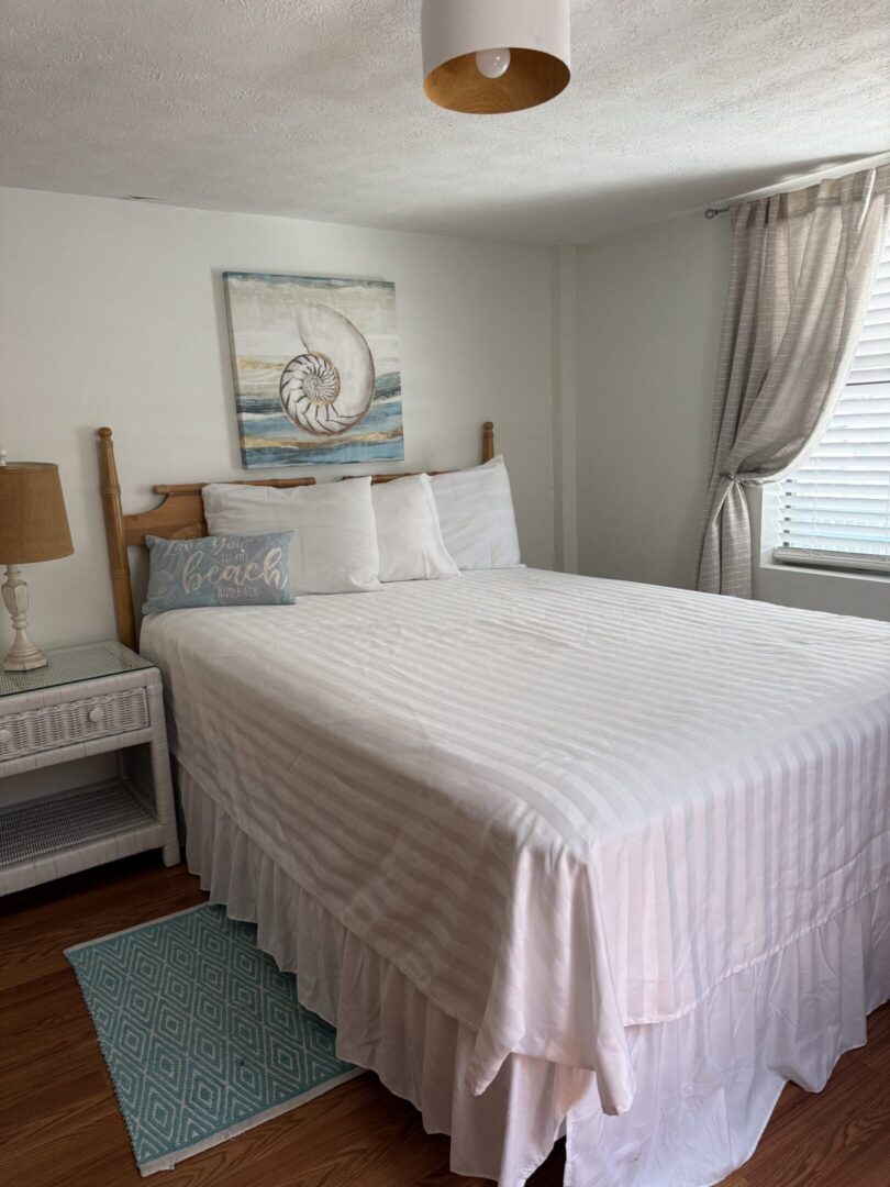 Neatly made bed with shell artwork
