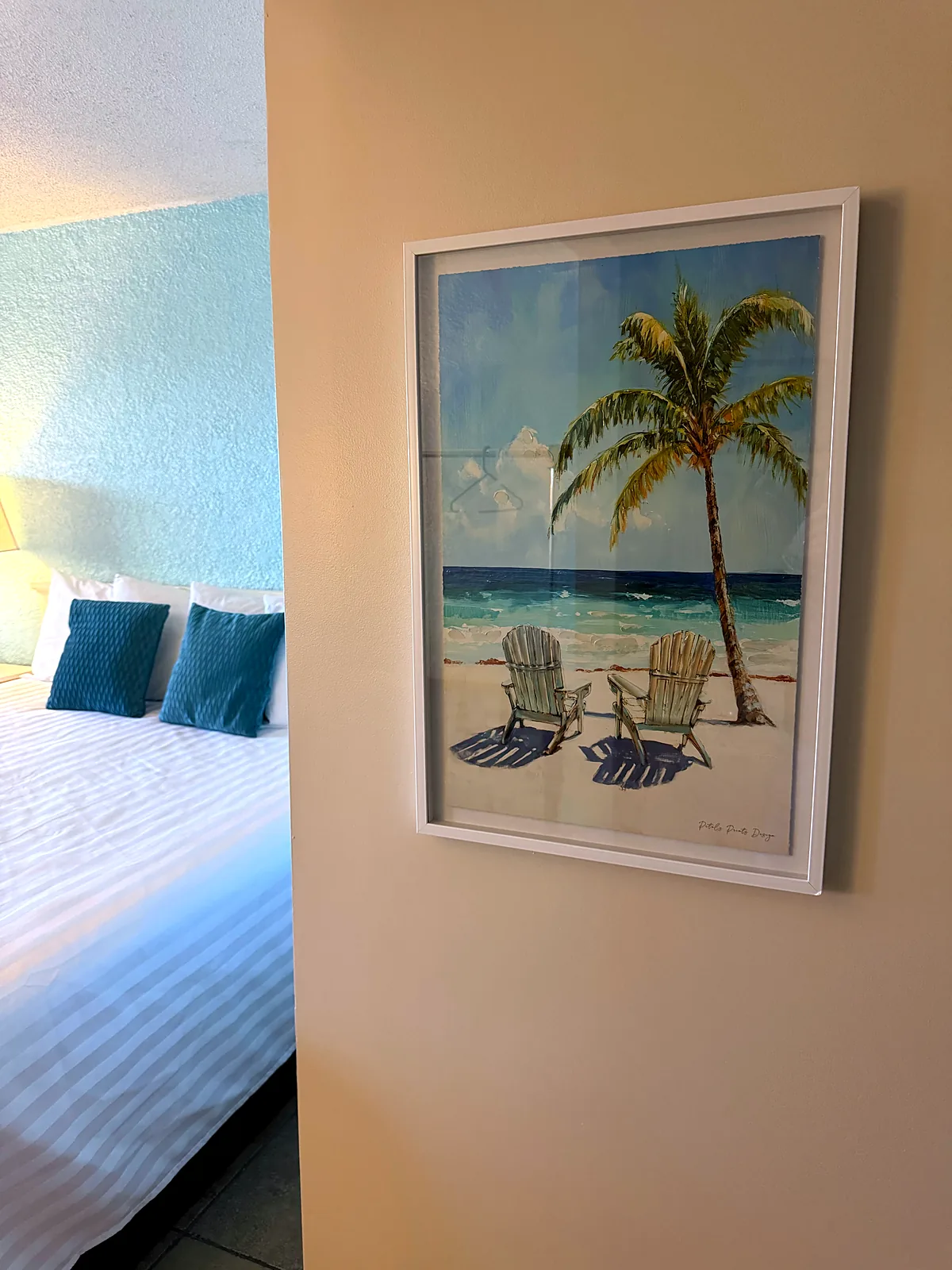 King bed with palm tree artwork above the headboard